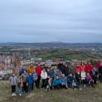 San Felixeko ikasle eta familia talde handi bat mendi baten gainean, harana eta itsasadarra atzean